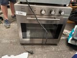 a man standing next to an oven that is on the ground