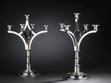 pair of silver candlesticks on a black background