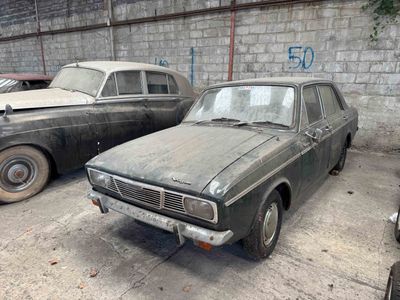 two old cars that are parked in a garage