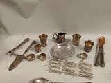 de nombreux objets en argent posés sur une table avec un fond blanc