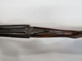 a hand holding a shotgun with a wooden handle