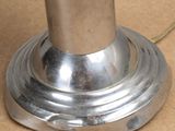 a close up of a silver lamp on a brown surface