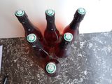 several bottles of beer sitting on top of a counter next to a notepad