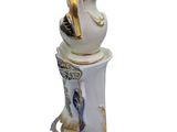 a white and gold teapot with a bird on top of it