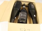 three bottles of wine in a cardboard box on a table