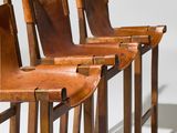 four leather bar stools in a row on a white background