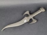 a silver dagger with a dragon head on it sitting on top of a table