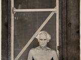 photographie en noir et blanc d'un vieil homme assis devant une fenêtre