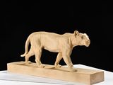 sculpture représentant un lion sur un bloc de bois, sur fond noir