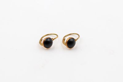 une paire de boucles d'oreilles en pierre noire sur fond blanc