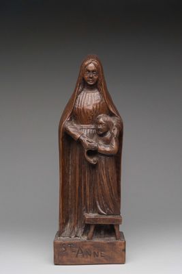 a wooden statue of a woman holding a child