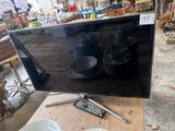 a flat screen tv sitting on a table with a remote control