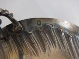 a close up of a silver vase on a table