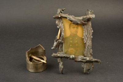 une petite statue représentant un homme assis sur une chaise, à côté d'une cigarette