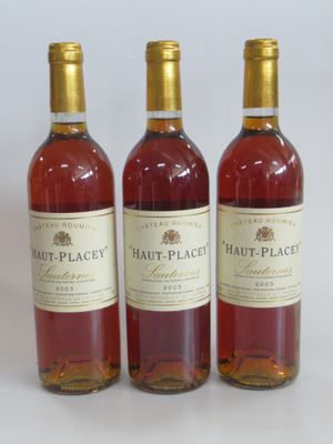 three bottles of wine sitting next to each other on a white surface