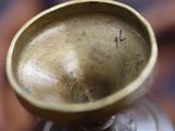 a small brass bowl sitting on top of a wooden table