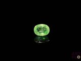 un gros plan d'une boule de verre verte posée sur une surface noire