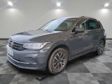 un SUV Volkswagen gris garé dans un garage au sol carrelé
