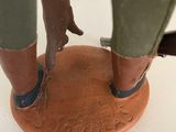 figurine of a man standing on a base with a dog on it ' s feet