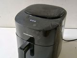 a black air fryer sitting on a counter top