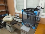 a 3d printer sitting on a desk next to a printer