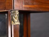 a brass head on the top of a wooden table