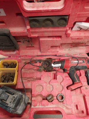 une mallette à outils rose, contenant des outils, posée sur une table