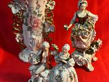 trois figurines assises côte à côte sur un tissu rouge