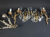 plusieurs appliques murales anciennes en laiton et cristal sur un fond noir