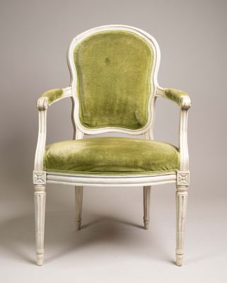 une chaise blanche et verte dont l'assise est rembourrée de vert