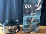 a crock pot on a table next to a box of cooking equipment