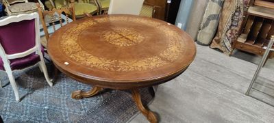 une table dont le plateau en bois est orné d'un motif floral
