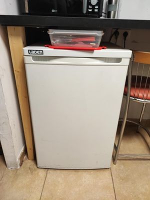a small white dishwasher in a small kitchen