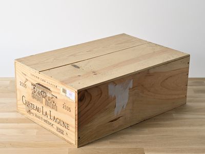 une caisse en bois sur laquelle est collée une étiquette, posée sur un plancher en bois