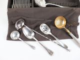 several spoons, forks, and spoon rest in a box on a table