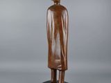 a wooden statue of a man with a hat and coat