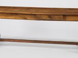 une vieille table en bois avec un tiroir en dessous, posée sur un plan de travail blanc