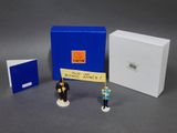 deux figurines qui se trouvent à côté d'une boîte