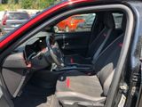 the interior of a red car with the door open and the driver ' s seat up