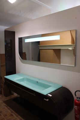 une salle de bains équipée d'un lavabo, d'un miroir et d'un extincteur