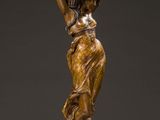 a bronze statue of a woman holding a pot on her head