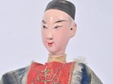 a small doll that is wearing a red and blue outfit