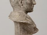 bust of a man on a pedestal on a wooden table