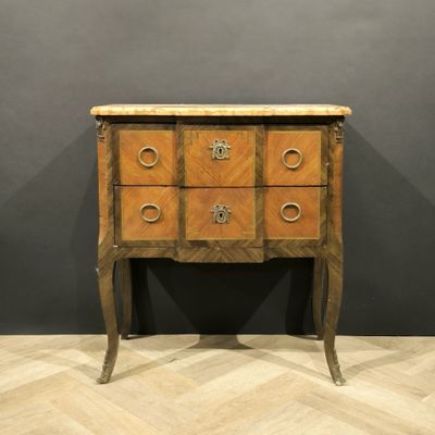 an antique chest of drawers with a marble top on a wooden floor