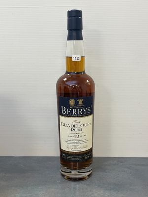 une bouteille de whisky posée sur une table, à côté d'un verre