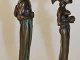 two figurines of a man and a woman standing next to each other