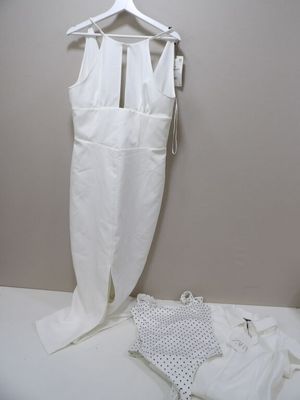 a white dress hanging on a hanger next to a pair of white pants