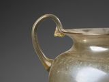 a glass vase with a handle on a table