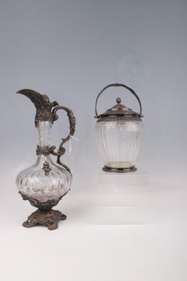 deux vases en argent et en verre posés sur une surface blanche