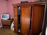 a room with a bed, a chair, a television, and a closet